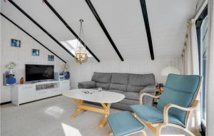 un salon avec un canapé, une table et des chaises dans l'établissement Two-Bedroom Holiday Home In Skjern, à Halby
