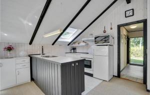 une cuisine avec des armoires blanches et un comptoir noir dans l'établissement Two-Bedroom Holiday Home In Skjern, à Halby