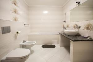 a white bathroom with a sink and a toilet at Mіnі Gotel Pozitiv in Horodets'ke