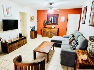 a living room with a couch and a tv at Appartement Coco Antilles ,vue mer, terrasse couverte 25m2,plage à pied in Sainte-Luce