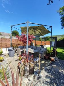 a patio with a couch and an umbrella at The little pink house in Thurles