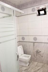 un baño con inodoro y ducha en Familihome, en Ganja