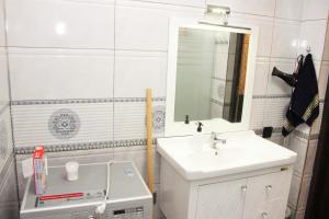 Un baño blanco con lavabo y espejo. en Familihome, en Ganja 4 fotos más