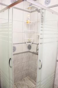 una ducha con puerta de cristal en un baño en Familihome, en Ganja