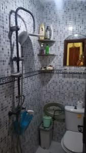 a bathroom with a shower and a toilet and a mirror at شقة للكراء اليومي للعائلات فقط وسط مدينة الجديدة تبعد 10 دقائق عن البحر in El Jadida