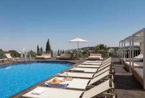 a hotel with a pool and lounge chairs at Cassia Hotel Jerusalem in Jerusalem