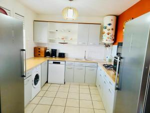 a kitchen with white cabinets and a washer and dryer at Appartement Coco Antilles ,vue mer, terrasse couverte 25m2,plage à pied in Sainte-Luce