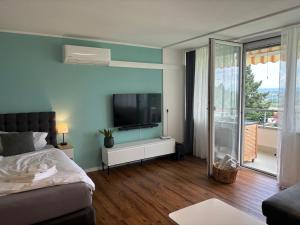 a bedroom with a bed and a flat screen tv at Ferienappartement Feyer in Oberteuringen