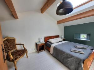 a bedroom with a bed and a chair at Gîte La Boutardière in Saint-Aubin-le-Cloud