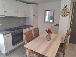 a kitchen with a table with a vase of flowers on it at studio au calme à VILLARS-SUR-VAR in Villars-sur-Var