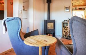 a table and chairs in a room with a wood stove at Cozy Home In Sexdrega With Sauna in Sexdrega +15 photos