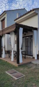 a pavilion with white curtains in front of a building at Casa rural La Abuela in El Ronquillo