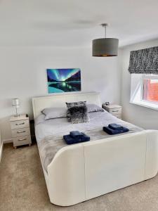 a white bed with two blue towels on it at York House luxury 2 bedroom apartment in Ashby de la Zouch