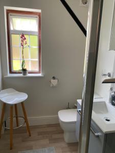 a bathroom with a toilet and a window and a stool at Coachmans Rest in Sandwich +10 photos