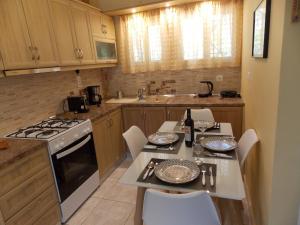 a kitchen with a table and a stove top oven at Vasiliki View in Áyios Pétros