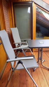 two chairs and a table on a porch at FeWo Wardersee in Rohlsdorf