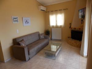 a living room with a couch and a glass table at Vasiliki View in Áyios Pétros