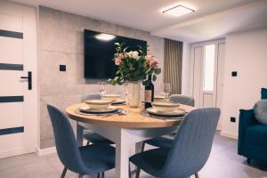 a dining room table with chairs and a vase of flowers at Zielony Apartament in Bachowice