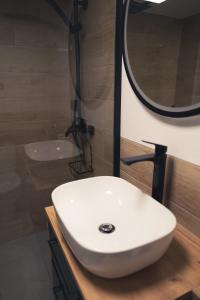 a bathroom with a white sink and a mirror at Zielony Apartament in Bachowice