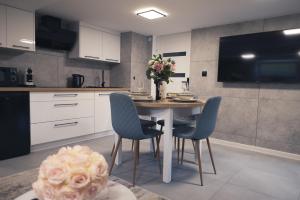a kitchen with a table with chairs and a vase of flowers at Zielony Apartament in Bachowice