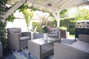 a patio with chairs and a table and a grill at Zielony Apartament in Bachowice