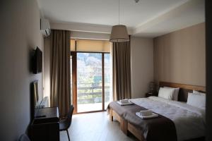 a hotel room with a large bed and a window at Family Hotel Stumari in Tbilisi City
