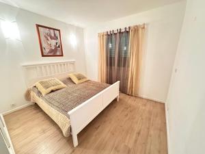 Un dormitorio blanco con una cama y una ventana. en Appartement Logement entier avec piscine, en Biguglia 3 fotos más