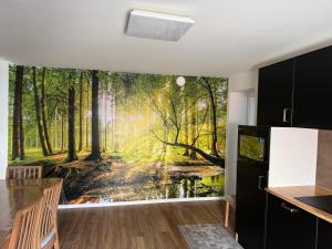 a kitchen with a forest mural on the wall at Apartament cozy in Villerupt