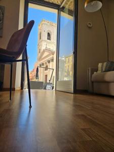 een stoel in een kamer met uitzicht op een toren bij Appartamento Adiosa in Cagliari