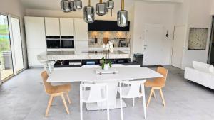 a white kitchen with a white table and chairs at Ortzadar Etxea in Arbonne