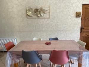 a dining room with a wooden table and chairs at Ch'ti NID au pays des lacs in Alièze
