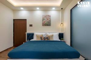 Un dormitorio con una gran cama azul con almohadas en Grey Hues with Swimming Pool & Lawn at Karjat by StayVista, en Karjat 31 fotos más