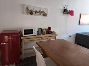 a kitchen with a table with a microwave and a table with a refrigerator at Acogedoras Habitaciones Privadas zona Costera Wifi in Morro del Jable