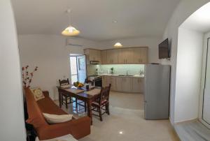 a kitchen and dining room with a table and a refrigerator at Irina's House in Sitia