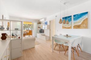 eine Küche und ein Wohnzimmer mit einem weißen Tisch und Stühlen in der Unterkunft WELCS APARTAMENTO 165 PDA con piscina in Platja  d'Aro