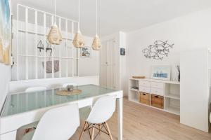 ein Esszimmer mit einem Glastisch und weißen Stühlen in der Unterkunft WELCS APARTAMENTO 165 PDA con piscina in Platja  d'Aro + 14 Fotos