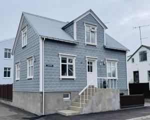 una casa azul con escaleras delante en AK Center - Hot Tub Villa, en Akureyri