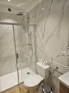 a white bathroom with a shower and a toilet at L'Escale in Bonifacio