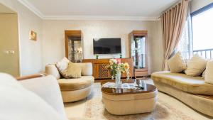 a living room with two couches and a tv at Duplex-Nyoum New Cairo in Cairo