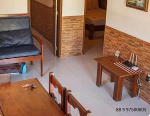 Una sala de estar con una silla y una mesa. en Casa com ar-condicionados e localização perfeita, en Canoa Quebrada