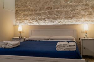 a bedroom with a blue bed with towels on it at Ninè in Pozzallo