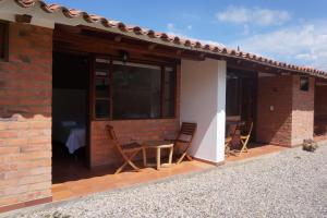 a patio of a house with chairs and a table at Hospedaje Plaza Villa de Leyva in Villa de Leyva
