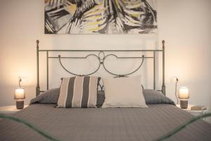 a bedroom with a bed with two lamps at Villa Silvia Apartments in La Maddalena