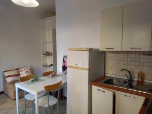 a kitchen with a white refrigerator and a table at A un passo da Siena in Tognazza