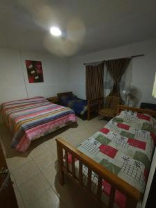 a bedroom with two beds and a chair in it at El Campanario in Malargüe