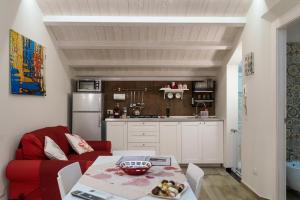 a living room with a red couch and a kitchen at Ninè in Pozzallo