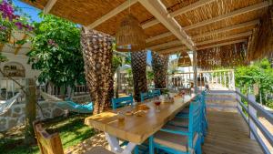 a long wooden table and chairs under a pergola at Golden Lighthouse Hotel in Patara