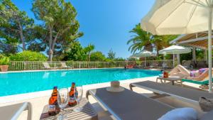 a swimming pool with a woman sitting on a chair next to a swimming pool at Golden Lighthouse Hotel in Patara