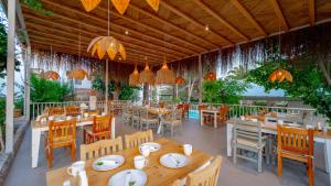 a restaurant with wooden tables and chairs and lights at Golden Lighthouse Hotel in Patara