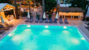 a large swimming pool with chairs and umbrellas at Golden Lighthouse Hotel in Patara